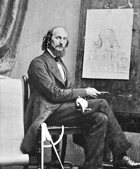 Conrad Wilhelm Hase in historischem Anzug sitzt auf Stuhl, hält Zeichenwerkzeug, vor Skizze eines Gebäudes an Staffelei